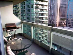 view from a top top-floor apartment balcony on a sunny day. a chair is visible on the left